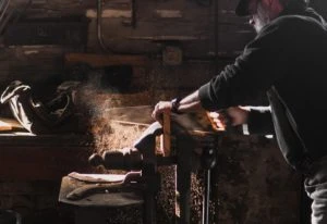 a man sawing a wood with a hand saw